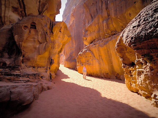 A narrow canyon with a person walking through.