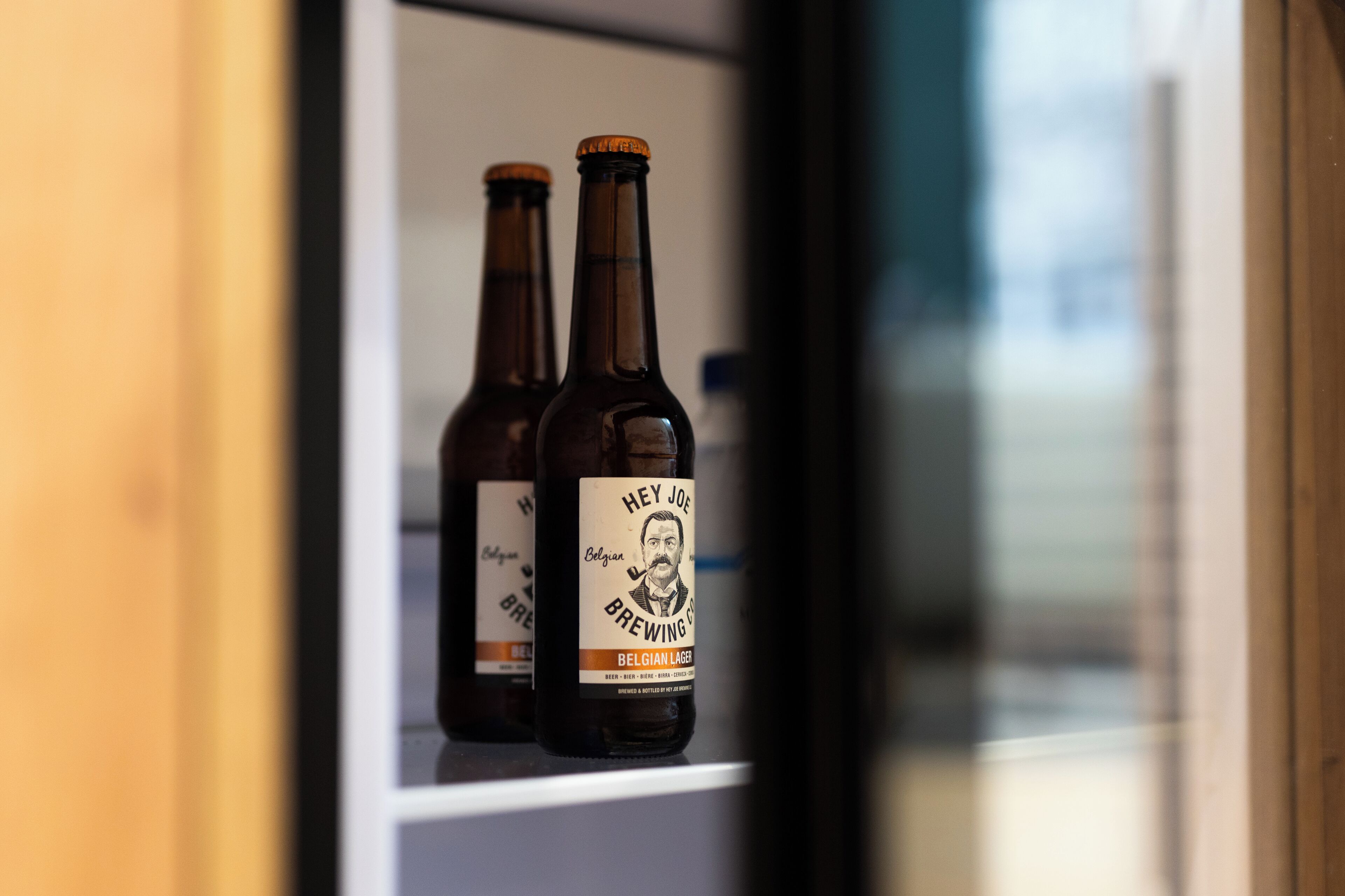 Dos botellas de cerveza belga en una estantería.