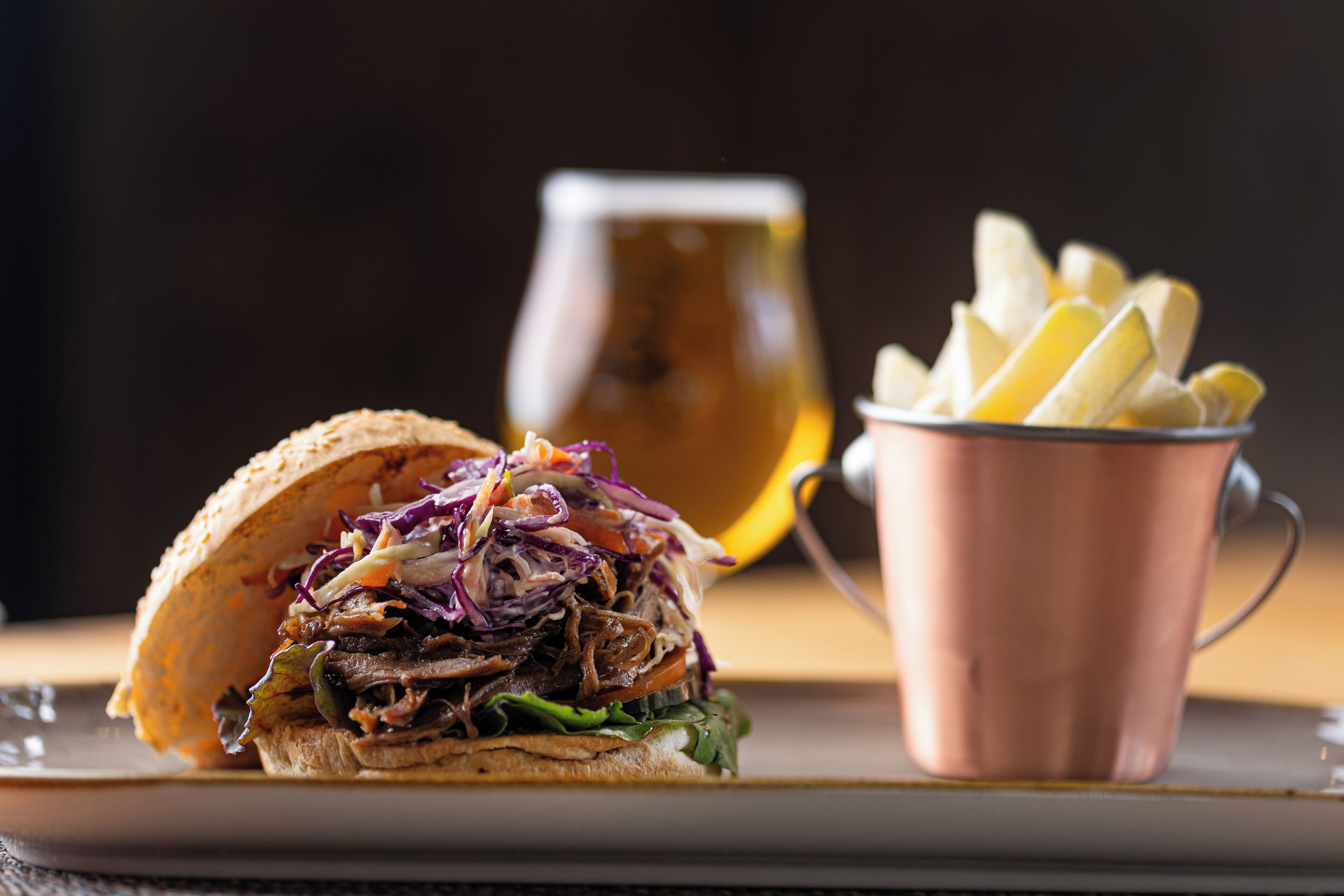 A sandwich with coleslaw and fries on a plate.