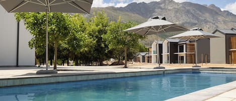 Piscine couverte, piscine extérieure, parasols de plage, chaises longues