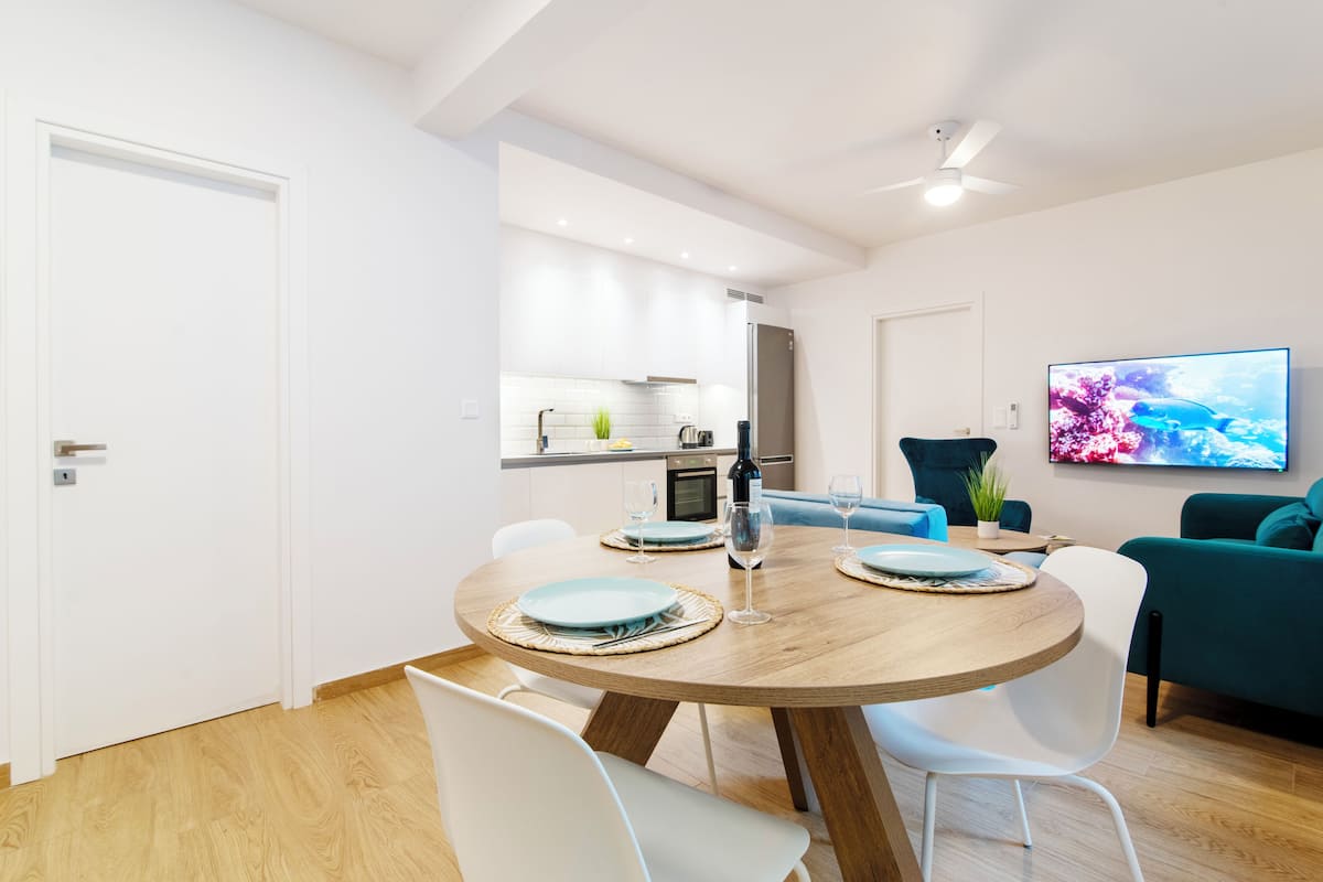 A modern kitchen with white cabinets, a built-in oven, and a refrigerator.