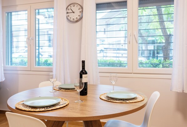 Una mesa de comedor con dos platos, dos copas de vino y una botella.