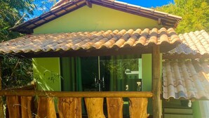 A two-story house with a balcony, a tiled roof, and a green exterior wall. - Pousada Cardeal Mota (Santana do Riacho)