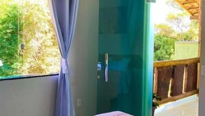 A bedroom with a bed, a TV mounted on the wall, a window with curtains, and a view of the outdoors. - Pousada Cardeal Mota (Santana do Riacho)