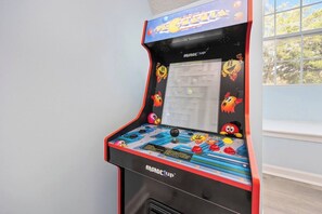 Une borne d’arcade rétro dotée d’une interface colorée et de personnages de dessins animés.