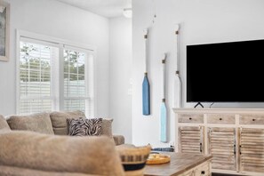 A living room with a sofa, a television, and a cabinet with drawers. - Arcadian Shores Home- Slps 14- 8 Beds- Retro Games (Myrtle Beach)
