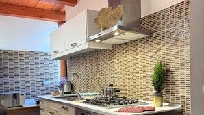 Una cocina moderna con armarios de madera, horno empotrado, estufa y salpicadero con un diseño geométrico.