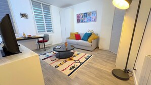 A modern living room with a sofa, coffee table, and a TV.