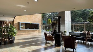 Un vestíbulo amplio con una recepción, zona de estar y grandes ventanales que ofrecen vistas al exterior.
