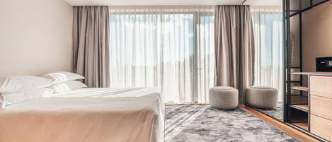 A modern bedroom with a large bed, a grey rug, and a wooden ceiling.