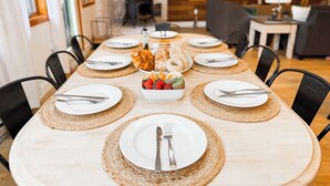 A dining area with a long table set for six, surrounded by chairs. - Perfect Summer Getaway-Near Storyland (Bartlett)