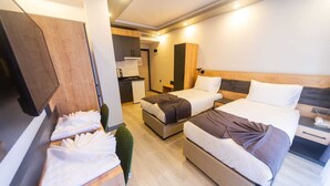 A hotel room with two beds, a kitchenette, and a seating area with a table and chairs. - Çamlıca Park Otel (Of)