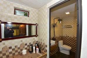 A bathroom with a tiled wall, a sink, a toilet, and a shower. - An's Space Sapa (Sa Pa)