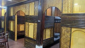 A room with bunk beds, wooden walls, and a tiled floor.