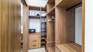 A walk-in closet with wooden shelving, a bench, and a hanging rod. - DANNY HOUSE 4 (Puerto Vallarta)