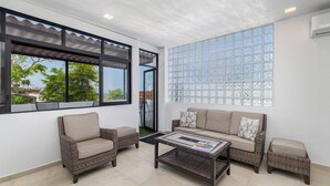 A spacious balcony with wicker furniture, a glass coffee table, and a view of the cityscape. - DANNY HOUSE 4 (Puerto Vallarta)