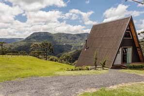 Situated in a lush landscape, this building features a unique triangular shape and large windows, offering a seamless connection to the outdoors.