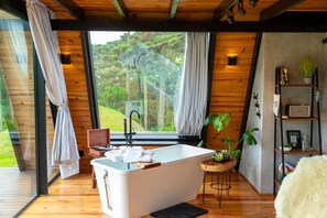 Relax in a serene space with a bathtub, wooden vanity, and a cozy reading nook.