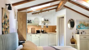 Une chambre avec un lit, une fenêtre et une vue sur la cuisine.