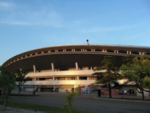 A large, circular stadium with a flat roof and multiple levels of seating.