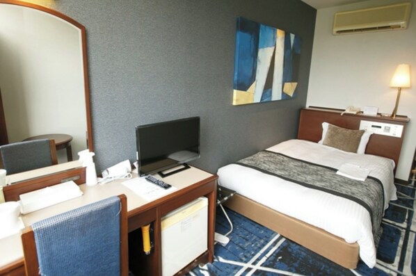 A hotel room with a bed, a desk with a chair, a television, a mirror, and a painting on the wall.