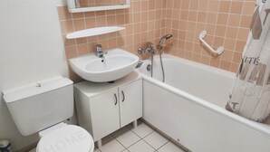 A bathroom with a toilet, sink, and bathtub. - Getaway for two: cosy apartment with balcony (Trouville-sur-Mer)