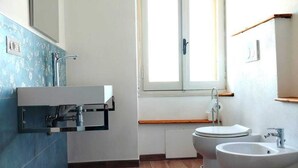 A bathroom with a toilet, bidet, and sink.