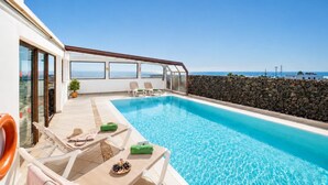 A rooftop swimming pool with lounge chairs, a stone wall, and a view of the sea. - Villa Asomada - Four Bedroom Villa, Sleeps 8 (La Asomada)