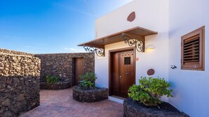 A building with a stone wall, a wooden door, and a small window. - Villa Asomada - Four Bedroom Villa, Sleeps 8 (La Asomada)