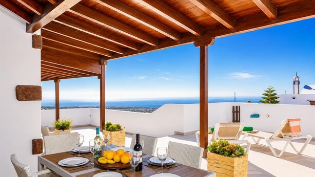 A rooftop terrace with a wooden pergola, dining table set for two, and a view of the sea and cityscape. - Villa Asomada - Four Bedroom Villa, Sleeps 8 (La Asomada)
