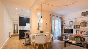 A modern living room with a dining area, a bookshelf, and a television. - Host Stay Osbourne Rest (Hove)