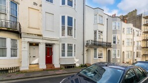 A row of terraced houses with a red door and a balcony. - Host Stay Grafton Suite (Brighton)