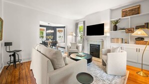 Ein modernes Wohnzimmer mit Kamin, Flachbildfernseher und Bücherregal.