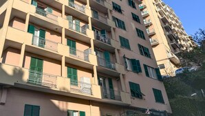 Un edificio residenziale a più piani con balconi e persiane verdi.