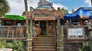 A rustic cottage-style restaurant with a wooden facade, a fish-shaped sign, and outdoor seating. - Spacious 4-bedroom house in delightful Sarasota with WiFi, AC (Sarasota)