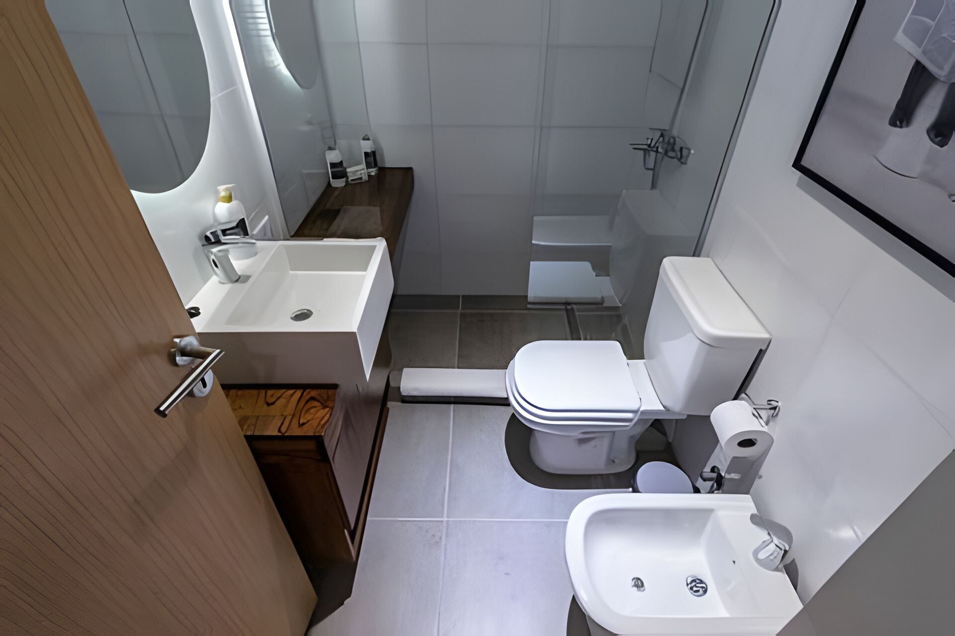 A compact bathroom with a sink, toilet, and bidet.