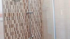 A shower with a tiled wall and a glass door. - Sassari Torres Rooms 2 (Sassari)