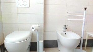 A bathroom with a toilet, bidet, and a bidet stand. - Sassari Torres Rooms 2 (Sassari)