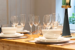 A dining table set with multiple wine glasses, bowls, and plates, indicating a formal dining setup. - Host Stay Luxe on Margaret Street (Brighton)