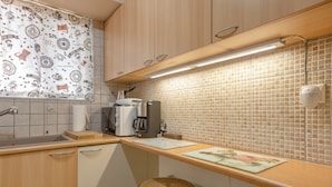 Eine kleine Küchenzeile mit Kaffeemaschine, Toaster und Spüle.