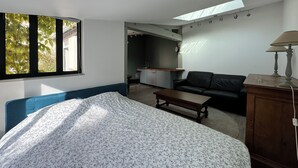 A bedroom with a bed, a sofa, a small table, a lamp, and a skylight. - Detached house with secure parking  (Vétheuil)