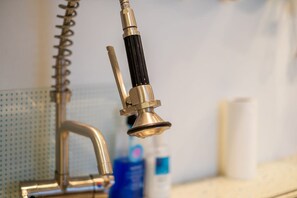 A bathroom faucet with a modern design, a towel dispenser, and a soap dispenser. - Host Stay Montpelier Colours (Brighton)