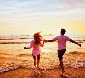A couple walking hand in hand on a beach at sunset. - 3BR All-Inclusive*$89PP*Beach*pool*shuttle*gated (Falmouth)