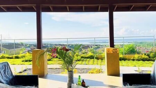 A covered outdoor area with a view of a green landscape and a body of water. - Girls Trip ! Stay, Play and Eat $29PP (Falmouth)