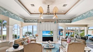 A spacious living room with a large TV, comfortable seating, and a view of the ocean. - Stunning Gulf waterfront pool and spa home (Marco Island)