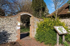 Enter Kipling Gardens through this historic stone archway, surrounded by lush hedges and trees.