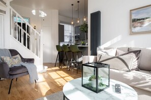 Relax in a spacious living area with a sofa, coffee table, and display case, perfect for unwinding.