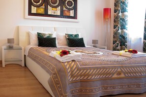 Un lit bien fait, avec une couvre-lit à motifs, deux oreillers et une tête de lit décorative.