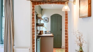 A kitchen with a brick archway, a sink, and a green door. - Host Stay Hanover Rest (Brighton)