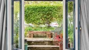A wooden bench on stone steps leading to a garden with a wrought iron gate. - Host Stay Hanover Rest (Brighton)